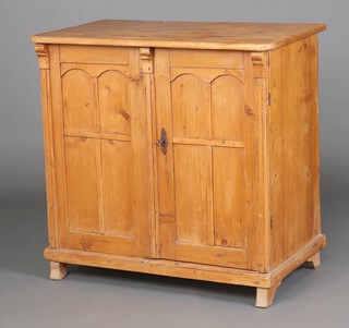 A 19th Century Continental pine cabinet with shelved interior enclosed by panelled doors 93cm h x 94cm w x 56cm d 