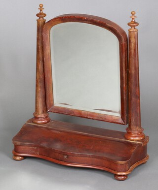 A Victorian arched bevelled plate dressing table mirror contained in a mahogany swing frame supported by 2 columns to the sides, the base of serpentine outline fitted a glove box 79cm h x 67cm w x 29cm d  