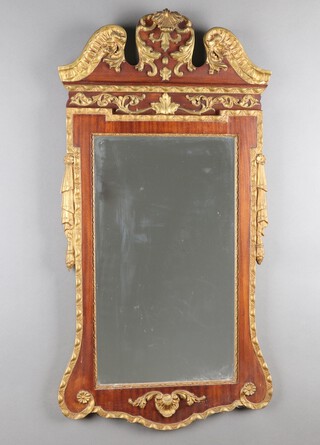 A 1920's Empire style rectangular bevelled plate wall mirror contained in a walnut and gilt painted plaster frame surmounted by a shell 109cm x 57cm 