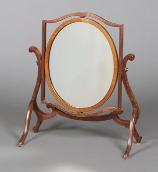 A Georgian style oval plate dressing table mirror contained in a mahogany swing frame, the back of the mirror fitted 3 shaped receptacles 61cm x 53cm x 23cm 