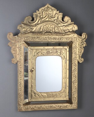 A 20th Century cushion shaped Indian plate mirror with embossed frame, the centre fitted a cupboard enclosed by a panelled door 70cm x 53cm 