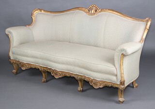 A Louis style carved and gilt painted wooden show frame 3 piece suite comprising 3 seat sofa, the seat of serpentine outline 97cm h x 200cm w x 57cm d  (seat 194cm x 44cm) and 2 matching armchairs 95cm h x 82cm w x 57cm d (seat 37cm x 41cm) 