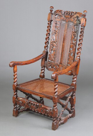A 17th Century carved oak open arm chair with pierced crown cresting rail, the back with carved and pierced floral panels and cane panels, caned seat, the arms with floral carving, raised on turned and block supports with X framed stretchers to the side and H framed stretcher to the base 113cm h x 53cm w x 52cm d (seat 32cm x 33cm) 