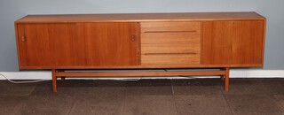A very large 1970's Swedish Hugo Troeds Bjarnum teak sideboard comprising from the right slide panels revealing two cupboards fitted sycamore veneer shelves,  4 long drawers with recessed handles  and a fall front drinks cabinet (currently locked), 78cm h 253cm w 42.5cm d 