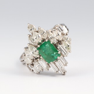 A white gold, testing as 18ct, vintage emerald and diamond cocktail ring, the baguette cut emerald approx. 1.25ct, 10 baguette cut diamonds each approx. 0.09ct and 12 elliptical diamonds each approx. 0.20ct, size U 1/2, 7.9 grams 