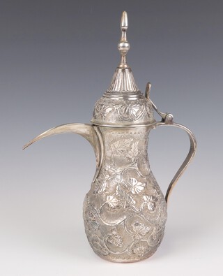 An Egyptian repousse silver coffee pot with scrolling leaf decoration and scroll handle, 29cm, 660 grams 