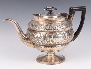 A George III silver baluster teapot with scrolling flowers and vacant cartouche, with ebony mounts, London 1800, 490 grams 