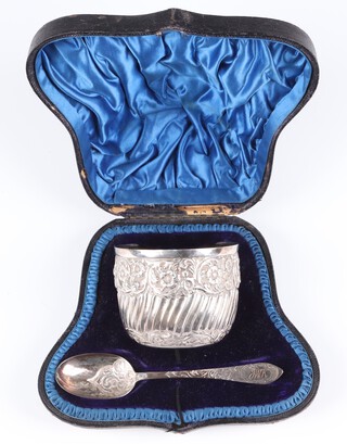 A Victorian repousse silver sugar bowl with scrolling floral decoration and engraved monogram, London 1899, together with a similar spoon with engraved monogram London 1898, 132 grams, cased 