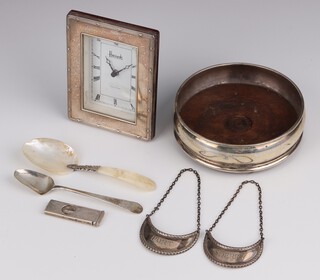 A Georgian style silver coaster London 1984 12cm, a silver mounted timepiece, comb, 2 spoons, a cigar cutter and 2 spirit labels, weighable silver 40 grams