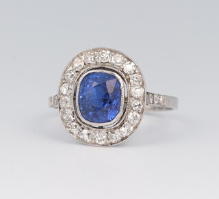 A platinum, sapphire and diamond cluster ring, the centre sapphire approx. 1.5ct surrounded by brilliant cut diamonds approx. 0.50ct, size Q, 3.7 grams 