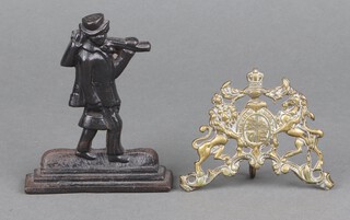 A Victorian pierced brass plaque in the form of The Royal Coat of Arms 7cm x 9cm x 10cm together with a Victorian cast iron bookend in the form of a journeyman 12cm x 10cm 