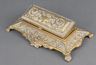 A Victorian cast brass rectangular stamp box the hinged lid cast a classical urn and swags, the interior fitted 5 sections raised on panelled feet 6cm x 21cm x 12cm 