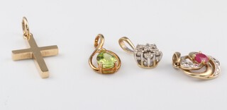A 9ct yellow gold tanzanite and diamond pendant, a 9ct gold cross pendant set a diamond, a ruby and diamond 9ct gold pendant, together with a gold paste set pendant, gross weight 3.3 grams  