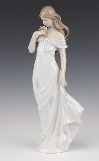 A Lladro figure of a standing lady holding a bunch of flowers, 6918 A Flower's Whisper, 34cm 