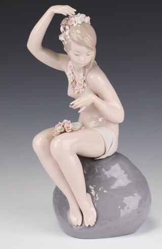 A Lladro figure of a semi clad lady sitting on rocks no. 1607 31cm 