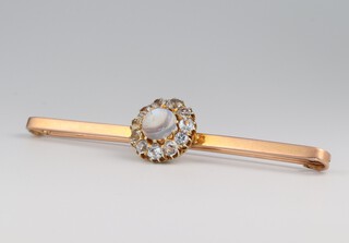 A 9ct yellow gold bar brooch set with a moonstone and surrounded by paste stones, 75mm