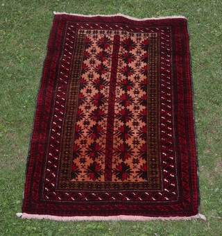 An orange, red and white ground Belouche rug with 18 stylised medallions to the centre within a multi row border 156cm x 90cm 
