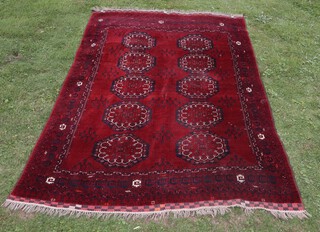 A red and blue ground Afghan carpet with 10 octagons to the centre within a multi row border 352cm x 229cm 