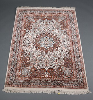 A white, brown and cream ground North Persian silk rug with central floral medallion within a multi row border 182cm x 121cm 