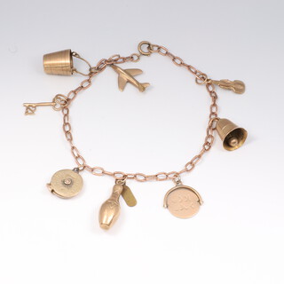 A 9ct yellow gold charm bracelet with eight 9ct gold charms including bell, bucket and violin, gross weight 12 grams