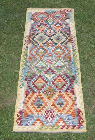 A white, black and green ground Chobi Kilim runner with overall diamond design 243cm x 80cm 