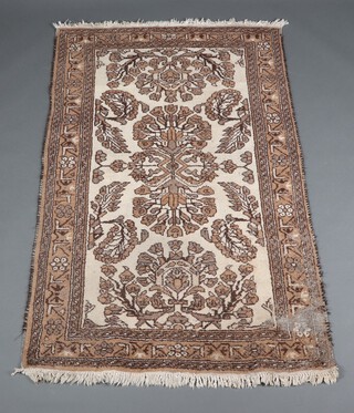 A white, black and tan ground Afghan rug with floral decoration 183cm x 112cm 