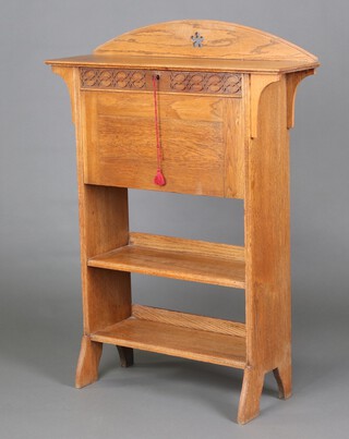 An Art Nouveau carved and pierced light oak student's bureau with arch shaped top carved a stylised star, the fall front with blind fret work decoration, interior fitted pigeon holes and 2 associated glass inkwells above 2 shelves 115cm h x 84cm w x 24cm 