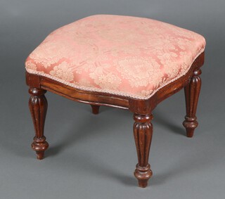 A Victorian mahogany stool of serpentine outline upholstered in pink and gold material, raised on turned and fluted supports 40cm h x 51cm w x 52cm d 