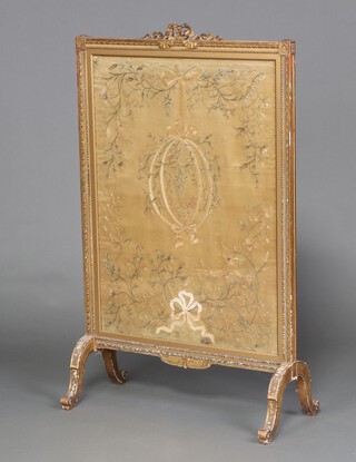 A Victorian fire screen with silk embroidered floral panel to the centre contained in a gilt painted wooden and oak frame with ribbon garland to the top 111cm x 68cm w x 33cm d 