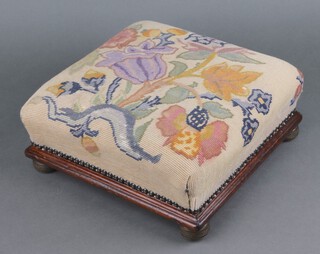 A Victorian square mahogany footstool with floral tapestry seat, raised on circular brass bun feet 12cm h x 33cm w x 33cm d 