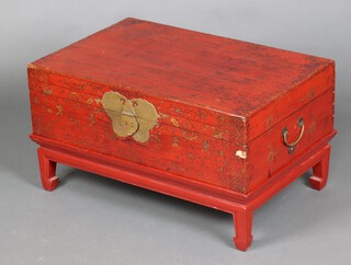 A rectangular Chinese red and gilt painted trunk with hinged lid and brass plate lock 42cm h x 77cm w x 50cm d 