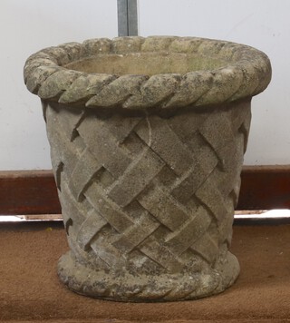 A circular garden urn with basket weave cast decoration 47cm x 40cm