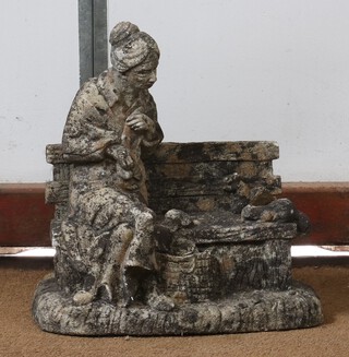 A well weathered concrete garden ornament in the form of a seated lady 32cm h x 33cm w x 13cm d