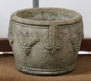 A circular well weathered concrete garden urn with cast grape decoration 30cm h x 37cm diam. 