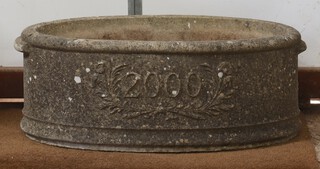 An oval well weathered concrete Millennium planter, dated 2000, 25cm x 67cm x 39cm 