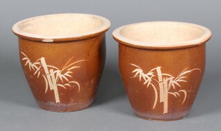 A pair of circular brown glazed terracotta plant pots decorated bamboo 32cm h x 37cm diam. (1 chipped)