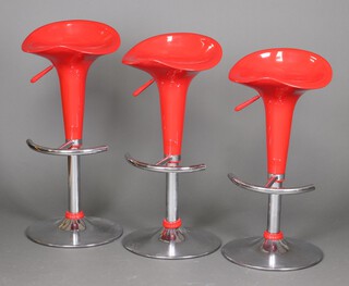 Three chrome and moulded red plastic revolving adjustable stools with shaped seats 85cm h x 38cm 