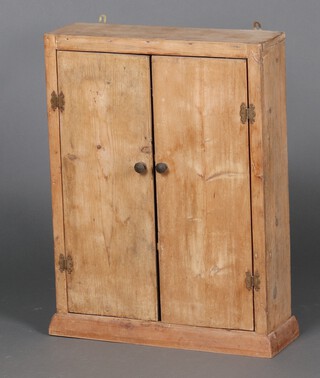 A 19th Century pine hanging cabinet enclosed by a panelled door 46cm h