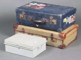 A blue fibre suitcase with numerous luggage labels including Williams Grand Hotel, Brunnene, Modean and others 20cm x 60cm x 8cm, a naval green cloth and leather suitcase with Southern Railways label 18cm x 67cm x 38cm and a grey painted metal deed box 