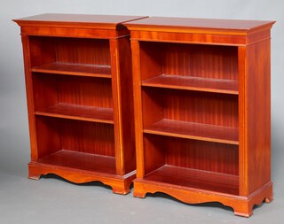 A pair of Georgian style mahogany bookcases with fluted columns to the sides, fitted adjustable shelves, raised on bracket feet 108cm h x 81cm w x 36cm d 