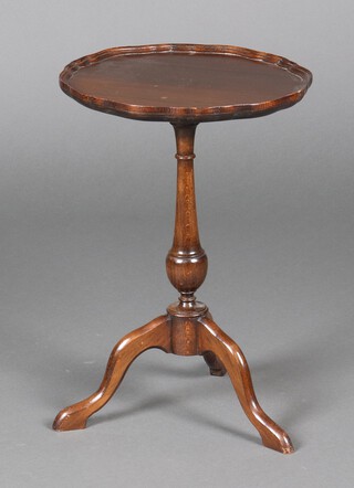 A circular Georgian style mahogany wine table with pie crust edge raised on pillar and tripod base 53cm h x 37cm diam. 