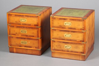 A pair of yew military style bedside chests of 3 drawers, the tops with green tooled leather surfaces 53cm h x 44cm w x 44cm d 