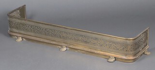 A 19th Century pierced brass fender raised on paw feet 21cm x 123cm x 31cm 