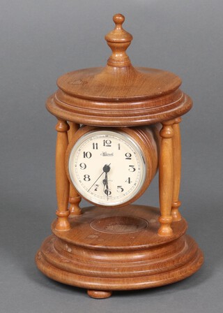 A quartz timepiece contained in a turned wooden case in the form of a temple urn 31cm h x 19cm w 