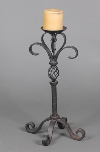 A wrought iron candle stand with fleur de lis decoration 58cm x 31cm x 31cm 