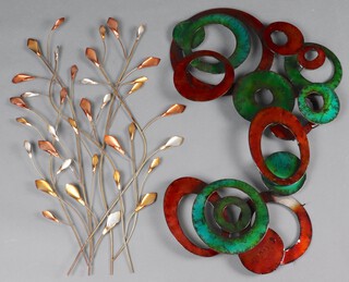 A circular pressed metal and enamelled wall plaque decorated various shapes 76cm x 51cm and 1 other in the form of  floral sprays 76cm x 47cm 