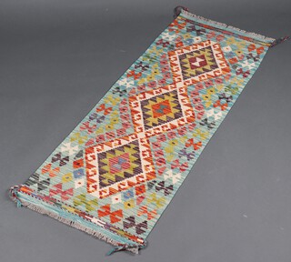 A turquoise, black and green ground Chobi Kilim runner with 3 diamonds to the centre 149cm x 53cm 