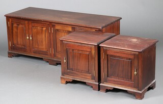 A pair of mahogany bedside cabinets enclosed by panelled doors, raised on bracket feet 45cm h x 40cm w x 37cm d together with a matching 4 door cupboard