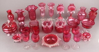 Eight Victorian cranberry glass wine glasses and a collection of cranberry ware including vases, jugs, bowl and covers