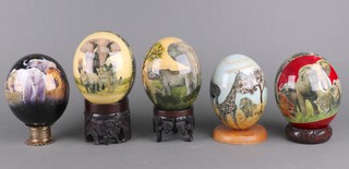 Five ceramic eggs decorated with African scenes on stands 20cm 